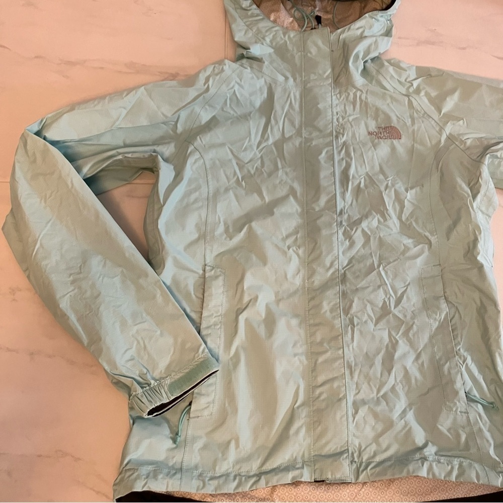 North face light teal rain jacket with hoodie.